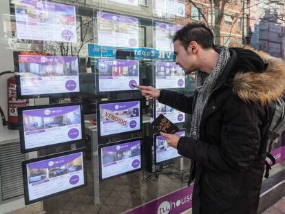 Un joven toma nota de pisos en venta en una agencia inmobiliaria en Madrid. En vídeo, solo uno de cada cinco jóvenes menores de 29 años consigue emanciparse.