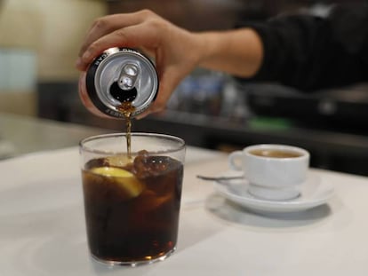 Una camarera sirve un refresco de cola. En vídeo, posibles medidas para reducir el consumo de bebidas azucaradas.