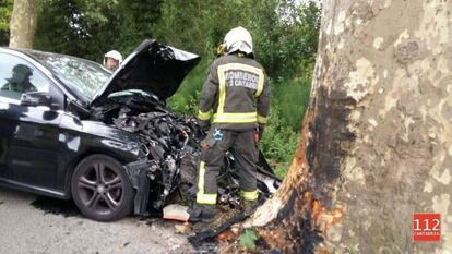 Varios bomberos, junto al vehículo siniestrado en Escalante.