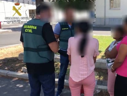 Guardias civiles con tres víctimas recién llegadas a España. En vídeo, agentes de la Guardia Civil detienen a siete personas implicadas en la trama.