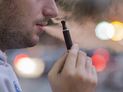 Un joven fuma un cigarrillo electrónico en una calle de Barcelona. En vídeo, Sanidad lanza una campaña contra las nuevas formas de fumar.