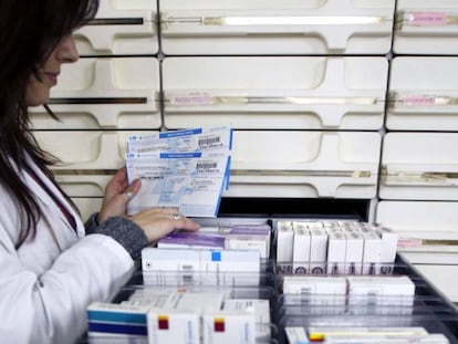 Una farmacéutica busca preparados en una farmacia. En vídeo, declaraciones de la ministra de Sanidad en funciones, María Luisa Carcedo.