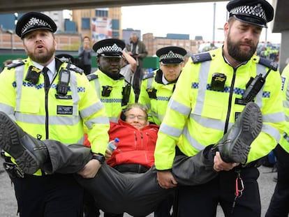 La policía londinense detiene a un activista de Extinction Rebellion en el aeropuerto de la Ciudad de Londres, el pasado jueves. En vídeo, 300 activistas de Extinction Rebellion detenidos durante una protesta en Bruselas, este sábado.