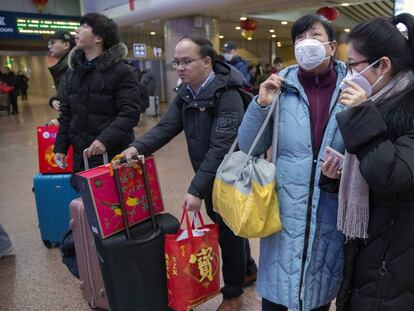 Un grupo de viajeros usa mascarillas en una estación ferroviaria en Pekín, este martes. En vídeo, aumentan a nueve los muertos por coronavirus de China.