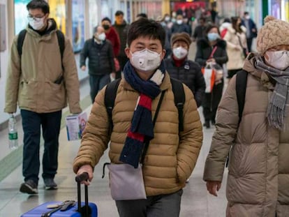 En foto, un grupo de personas, este viernes con mascarillas en una estación ferroviaria en Shanghái (China). En vídeo, las claves del Coronavirus.