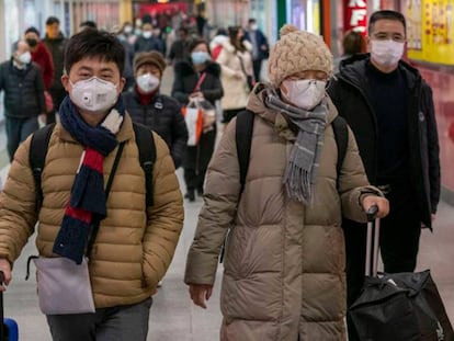 En foto, un grupo de personas, este viernes con mascarillas en una estación ferroviaria en Shanghái (China). En vídeo, las claves del Coronavirus.