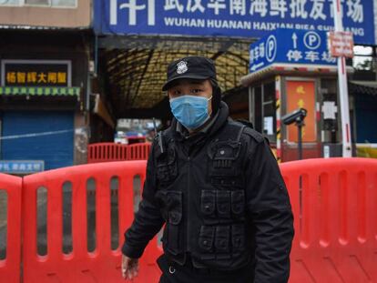 Acceso al mercado de Wuhan, vigilado este domingo.