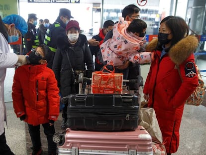 Un médico toma la temperatura a los viajeros antes de embarcar en el aeropuerto chino de Changsha, este lunes. En vídeo, las declaraciones de la ministra de Sanidad de Baviera.