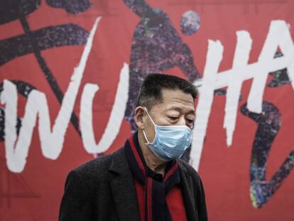 Un hombre se protege con una mascarilla en la ciudad de Wuhan. En vídeo, las claves del coronavirus.