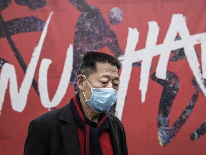 Un hombre se protege con una mascarilla en la ciudad de Wuhan. En vídeo, las claves del coronavirus.