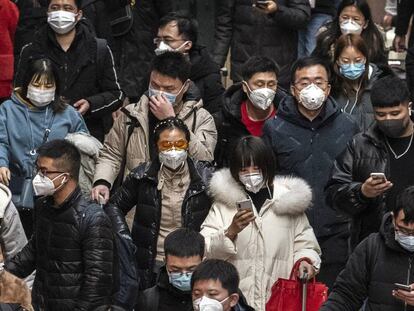 Pasajeros con mascarillas, en la estación de tren de Pekín (China). En vídeo, declaraciones del director general de la OMS, Tedros Adhanom Ghebreyesus.