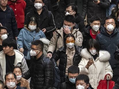 Pasajeros con mascarillas, en la estación de tren de Pekín (China). En vídeo, declaraciones del director general de la OMS, Tedros Adhanom Ghebreyesus.