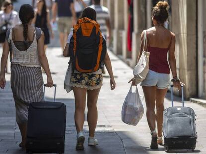 Tres turistas con sus maletas, en Barcelona. En vídeo, la embajada de EE.UU alerta sobre las violaciones a jóvenes en España.