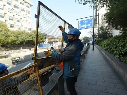 Trabajadores de Hangzhou instalan vallas en las carreteras para impedir la movilidad y hacer frente a la expansión del coronavirus.