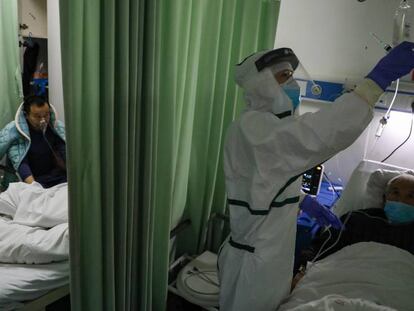 Una enfermera atiende a un afectado por coronavirus en un hospital de Wuhan. En vídeo, ascienden a 724 muertos dentro de China.