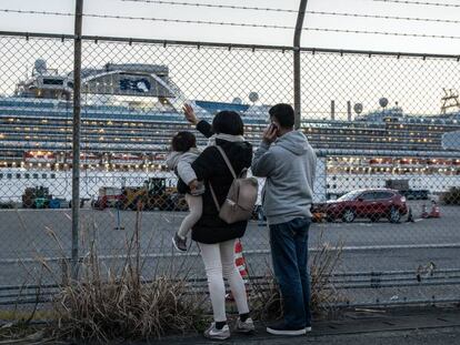 Unas personas saludan a su familia que se encuentra a bordo del crucero 'Diamond Princess'. En vídeo, declaraciones del ministro japonés de sanidad.