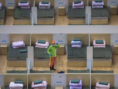 Un hospital temporal instalado en un pabellón deportivo de Wuhan. En vídeo, Wuhan reduce su número de contagios y endurece las medidas de control.