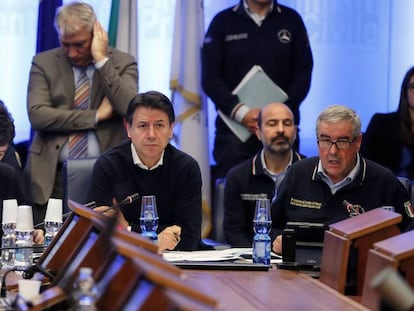 El primer ministro italiano, Giuseppe Conte (centro), en el gabinete de crisis por el coronavirus. En vídeo, sus declaraciones en la rueda de prensa del sábado celebrada en Roma.