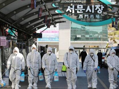 Un grupo de trabajadores desinfecta un mercado en Daegu, Corea del Sur, este domingo.