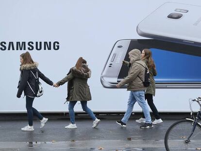 Varias personas pasan por delante de un anuncio del Samsung Galaxy S7, en una calle de Berlín.