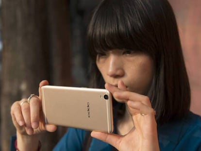 Una mujer utiliza el móvil OPPO R9.