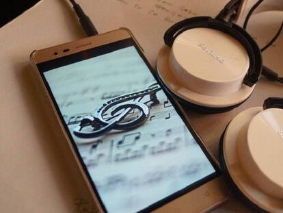 Un 'smartphone' junto a unos auriculares.