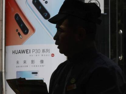 Un habitante de Pekín pasa al lado de un anuncio reciente de Huawei. En vídeo, el gigante tecnológico Google rompe con Huawei.