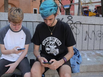 Dos usuarios teclean en sus móviles.