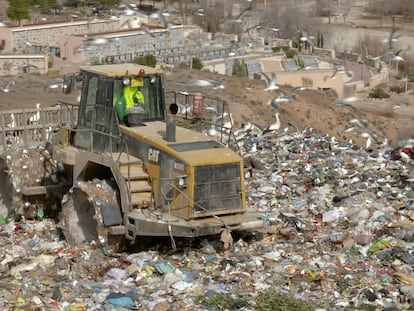 Una excavadora trabaja sobre la basura del vertedero.