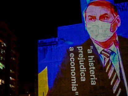 Imagen de Bolsonaro con la frase "La histeria daña la economía" proyectada contra un edificio.