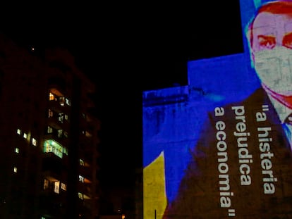 Imagen de Bolsonaro con la frase "La histeria daña la economía" proyectada contra un edificio.