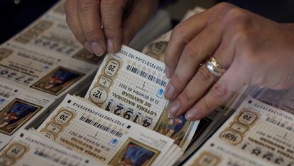 Una mujer coge un décimo del Sorteo Extraordinario de la Lotería de Navidad.
