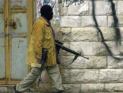 Un palestino armado camina por una calle cercana al lugar del enfrentamiento con los israelíes en Nablús.