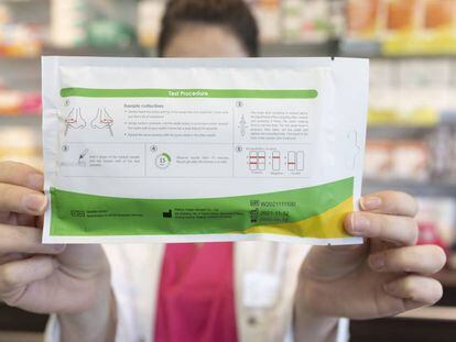Una farmacéutica muestra un test de antígenos en una farmacia, en Madrid.