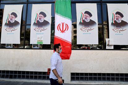 Un hombre pasa ante la oficina de un candidato a las presidenciales del próximo 18 de junio, este lunes en Teherán.