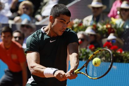 El español Carlos Alcaraz devuelve una bola ante Novak Djokovic, durante la semifinal del Mutua Madrid Open en la Caja Mágica.