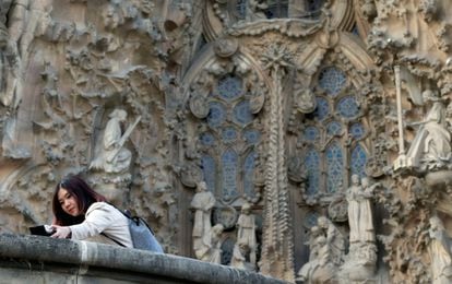 Una turista se fotografía ante la fachada de la Sagrada Familia, en Barcelona (España).