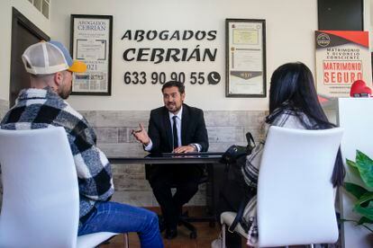 Alberto García Cebrián habla con unos clientes que han ido al despacho a informarse después de una separación en Leganés, Madrid.