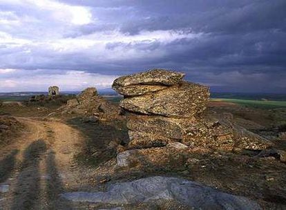 Camino que recorre el yacimiento de petroglifos de Domingo García, con la ermita de San Isidro al fondo.