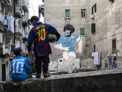 Dos niños lucen las camisetas de Maradona y Messi en el barrio de Forcella (Nápoles).