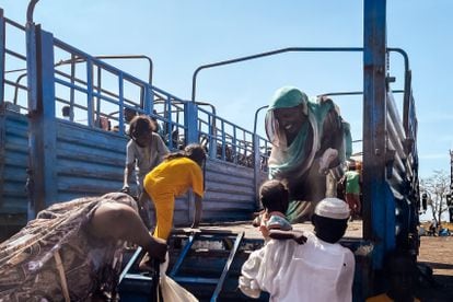 Una mujer subida en el camión con destino a Renk, en Sudán del Sur, recoge a su hija, que ha estado en brazos de un señor mientras ella accedía al vehículo. La Agencia de la ONU para los refugiados (Acnur) y la Organización Internacional de las Migraciones (OIM) se encargan del traslado de refugiados, pero no tienen medios suficientes para dar una respuesta humanitaria adecuada.