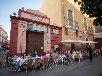 Clientes de un bar del barrio de Santa Cruz (Sevilla) comiendo este jueves en mesas situadas en la puerta del colegio San Isidoro.
