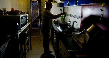Una dona cuina en un habitatge sense llum ni aigua.
