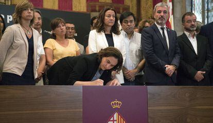 La alcaldesa de Barcelona, Ada Colau, acompa&ntilde;ada de autoridades, firma en el libro de condolencias abierto en el Ayuntamiento.  