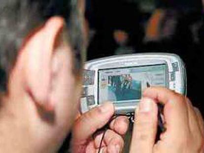 Una persona visiona un vídeo a través de su móvil