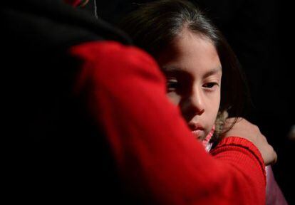 Una niña es confortada por su madre en una vigilia en Newtown