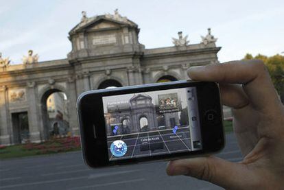 Un turista utiliza su iPhone para situarse en la plaza de la Independencia de Madrid.