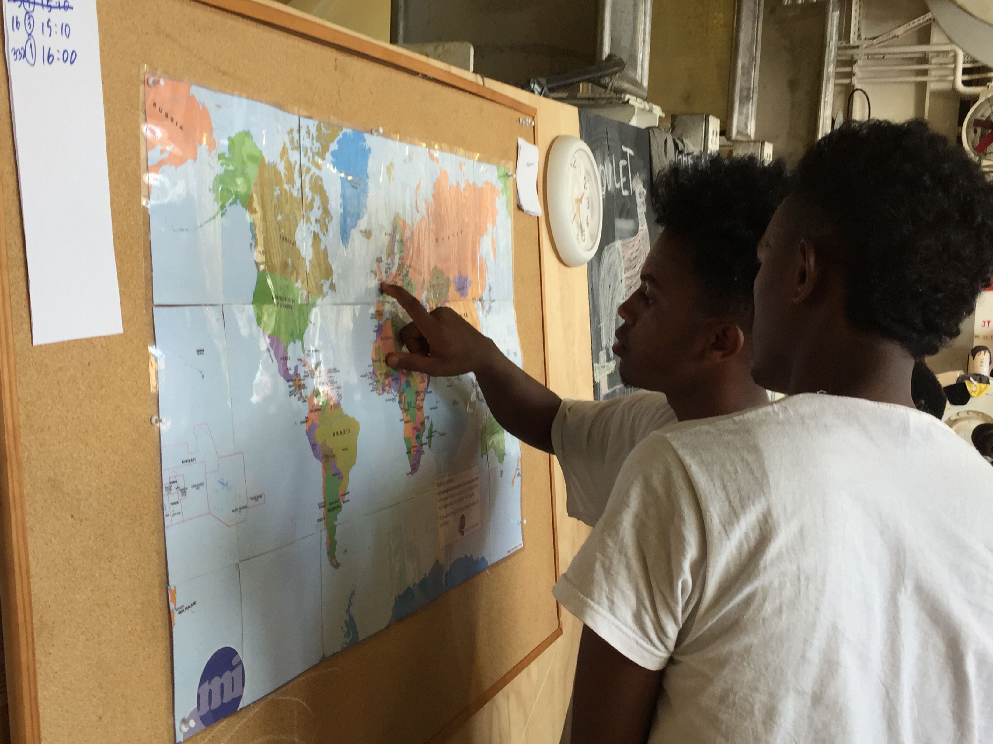 Dos adolescentes mirando un mapa del mundo a bordo del 'Geo Barents'.