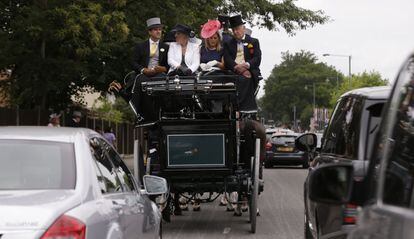 Un grupo de aficionados viaja en un carro de caballos con destino a las tradicionales carreras de caballos de Ascot (Inglaterra).
