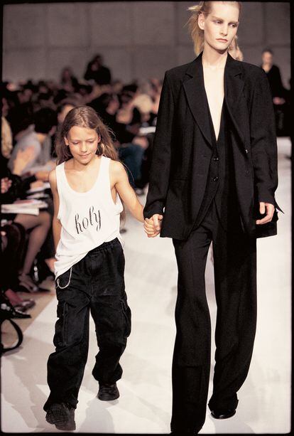 Desfile de la primavera/verano 1998 en la que aparece el hijo de la diseñadora cuando era un niño cerrando el show de la mano de la modelo Kirsten Owen.